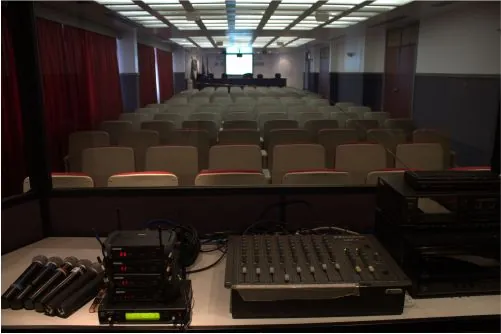 Mesa de som e plateia em auditório institucional
